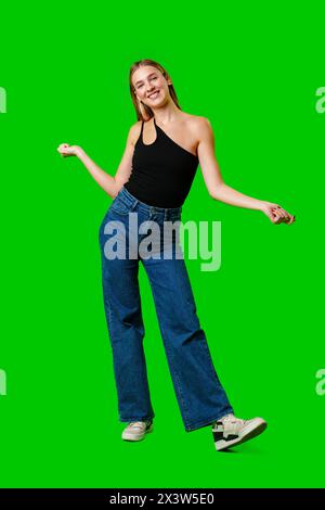 Die junge Frau posiert für das Bild vor grünem Hintergrund. Stockfoto
