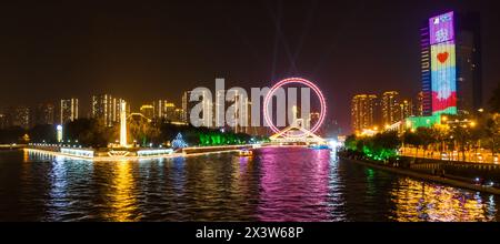 Panoramablick bei Nacht über das beleuchtete Riesenrad in Tianjin, China Stockfoto