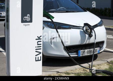 Frankreich. Seine et Marne. Region Coulommiers. Renault Zoe Elektroauto lädt an einem kostenlosen Schneider Electric Terminal in einem Einkaufszentrum auf. Stockfoto