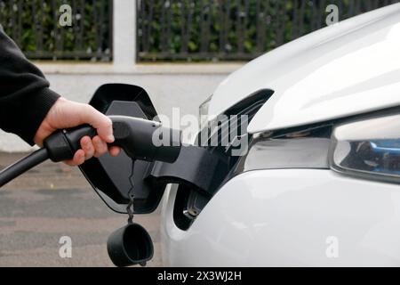 Frankreich. Seine et Marne. Elektroauto Renault Zoe. Nahaufnahme eines Mannes, der sein Elektroauto verbindet. Kabeltyp 2. Stockfoto