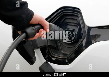 Frankreich. Seine et Marne. Elektroauto Renault Zoe. Nahaufnahme eines Mannes, der sein Elektroauto verbindet. Kabeltyp 2. Stockfoto