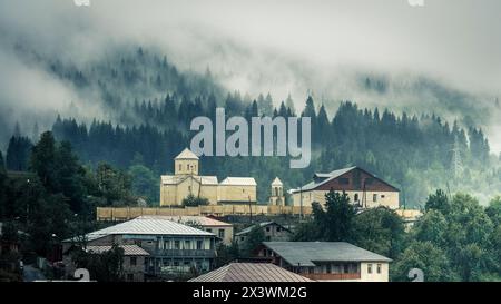 Blick auf die Kirche im Nebel, Mestia, Georgia. St. Nikolaus Kirche in Mestia Stockfoto