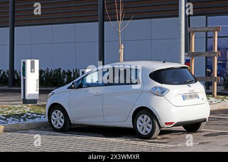 Frankreich. Seine et Marne. Region Coulommiers. Gewerbegebiet. Elektrisches Renault Zoe-Auto lädt an einem kostenlosen Schneider Electric EVLINK-Terminal auf. Stockfoto