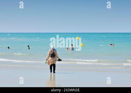 Frankreich. Normandie. Departement Manche. Granville im Sommer. Blick von der Küste und einem Teil des Strandes. Junge verschleierte muslimische Frau beobachtet sie Stockfoto