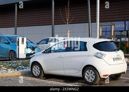 Frankreich. Seine et Marne. Region Coulommiers. Gewerbegebiet. Elektrische Renault Zoe Autos laden an einem kostenlosen Schneider Electric EVLINK Terminal auf. Stockfoto