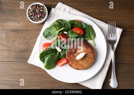 Leckeres vegetarisches Kotelett mit Gemüse auf Holztisch, flach gelegt Stockfoto