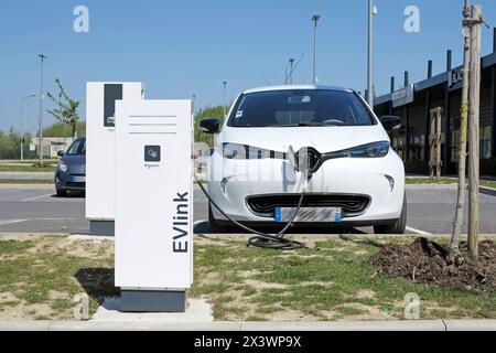 Frankreich. Seine et Marne. Region Coulommiers. Renault Zoe Elektroauto lädt an einem kostenlosen Schneider Electric Terminal in einem Einkaufszentrum auf. Stockfoto
