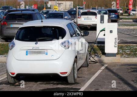 Frankreich. Seine et Marne. Region Coulommiers. Gewerbegebiet. Elektrisches Renault Zoe-Auto lädt an einem kostenlosen Schneider Electric EVLINK-Terminal auf. Stockfoto