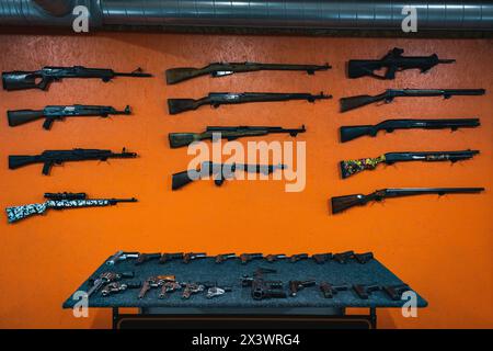 Schusswaffen, Gewehre, Pistolen, Revolver und Schrotflinten auf einem Schießstand. Stockfoto