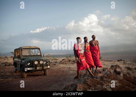 Drei Maasai Safari Guides stehen in der Nähe eines Landrovers für ein Porträt bei Sonnenuntergang. Die Reiseleiter arbeiten mit der Sirikoi Lodge in Lewa Wilderness, Kenia. Stockfoto