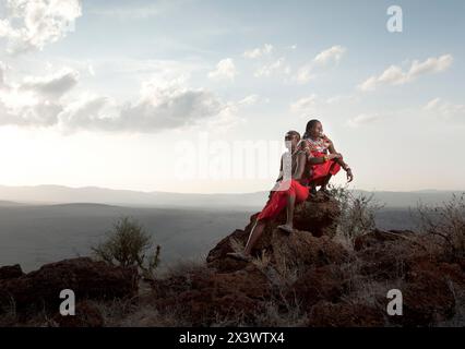 Zwei kenianische Safari-Guides ruhen auf einem Felsen auf einem Hügel in Lewas Wilderness, Kenia. Stockfoto