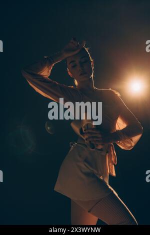 Junge müde Ballerina mit spitzenschuhen in den Händen, die sich nach dem Training vor dem Rampenlicht entspannen. Anmutig schöne Ballerina. Ballettkunst, Grac Stockfoto