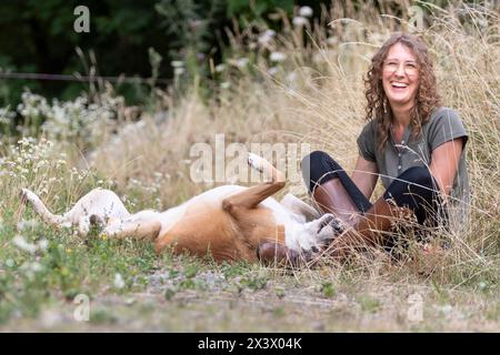 Frau, die mit einem Mischhund spielt (Boxer x ?). Deutschland Stockfoto