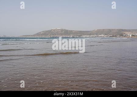 Wellen des Atlantiks in der afrikanischen Stadt AGADIR in Marokko, klarer blauer Himmel an 2023 warmen, sonnigen Wintertagen im Januar. Stockfoto
