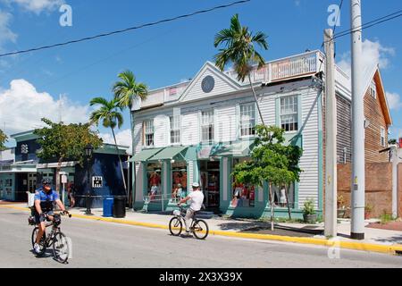 USA. Florida. Die Tasten. Key West. Historisches und touristisches Zentrum. Touristen- und Polizeibeamter, der Fahrrad fährt. Stockfoto