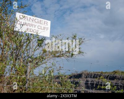 April 2024: Schild am Rand der Klippe und Sicherheitshinweise am Callow Hill Steinbruch oberhalb des Somerset Dorfes Cheddar. Stockfoto