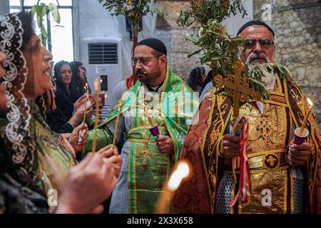 Bartella, Irak. April 2024. Die Priester halten das Kreuz während des Palmensonntaggottesdienstes, der den Beginn der Karwoche für orthodoxe Christen in der syrisch-orthodoxen Kirche Mart Shmoni markiert. Quelle: SOPA Images Limited/Alamy Live News Stockfoto