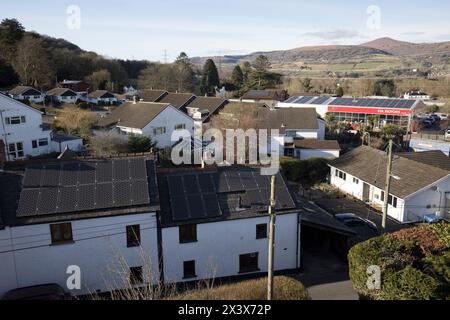 Solarpaneele auf Haus- und Geschäftsdächern, wobei eines von Schatten betroffen ist, Llanfoist, Wales, Großbritannien Stockfoto