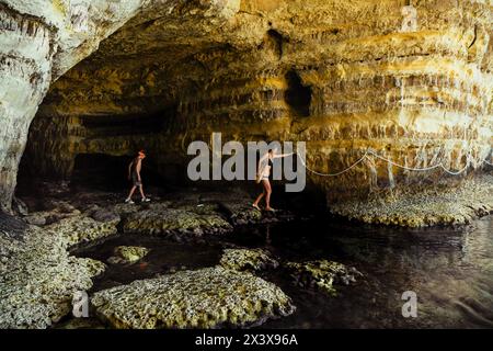 Frau Touristen erkunden Ayia napa Bucht Küste mit kristallklarem, blauem mittelmeer Wasser und ruhigen felsigen Stein Meer Höhlen. Besichtigungspfad mit Seilen Stockfoto