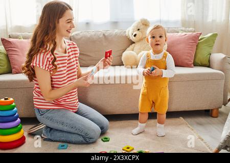 Eine junge Mutter sitzt fröhlich auf dem Boden, spielt mit ihrer Tochter und schafft eine warme und liebevolle Verbindung zwischen ihnen. Stockfoto