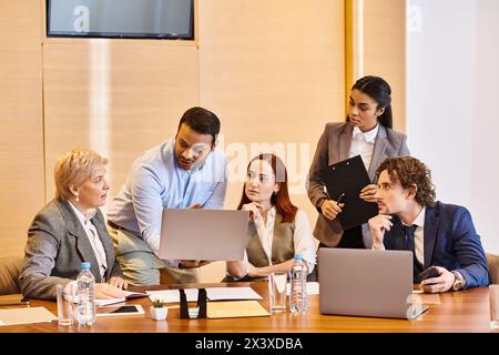 Verschiedene Gruppen von Geschäftsleuten, die an einem Tisch an Laptops arbeiten. Stockfoto