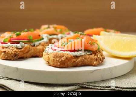 Leckere Kanapees mit Lachs, Gurke, Rettich und Frischkäse auf dem Tisch, Nahaufnahme Stockfoto