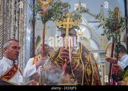 Bartella, Irak. April 2024. Ein Priester leitet den Palmensonntaggottesdienst, der den Beginn der Karwoche für orthodoxe Christen in der syrisch-orthodoxen Kirche Mart Shmoni markiert. (Foto: Ismael Adnan/SOPA Images/SIPA USA) Credit: SIPA USA/Alamy Live News Stockfoto