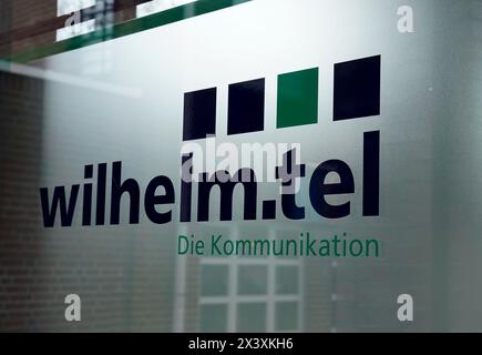 Norderstedt, Deutschland. April 2024. Ansicht des Wilhelm.tel GmbH-Logos an der Glasfassade des Service-Centers. Quelle: Marcus Brandt/dpa/Alamy Live News Stockfoto