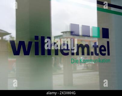 Norderstedt, Deutschland. April 2024. Ansicht des Wilhelm.tel GmbH-Logos an der Glasfassade des Service-Centers. Quelle: Marcus Brandt/dpa/Alamy Live News Stockfoto
