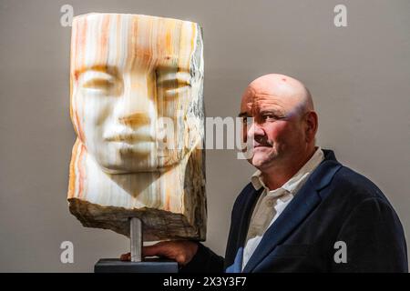 London, Großbritannien. April 2024. Paul Vanstone (im Bild), mit dem iranischen Onyx Head, 2023 - Eine Vorschau auf „Kunst für AM BUS“, die schulbasierte Kunst als Therapie in einem Doppeldeckerbus anbietet, um das Wohlbefinden junger Menschen zu unterstützen. Der Verkauf umfasst mehr als 30 Werke und wird vom 29. April bis 7. Mai 2024 in der New Bond Street Gallery von Sotheby ausgestellt. Die Werke werden vom 29. April bis zum 10. Mai 2024 um 17:00 Uhr über eine Online-Auktion, Powered by Artsy, verkauft. Der Erlös geht an den Bus. Guy Bell/Alamy Live News Stockfoto