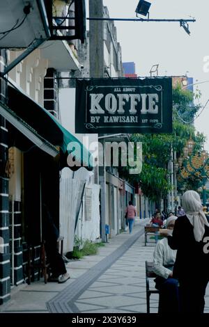 Kaffeeschild am Straßenrand mit alten Gebäuden Stockfoto