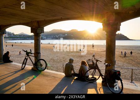 Paare mit ihren Fahrrädern, Sonnenuntergang am La Concha Beach, Donostiarra Juwel schlechthin, Wahrzeichen der Stadt, unvergleichliche Lage, es liegt in Th Stockfoto