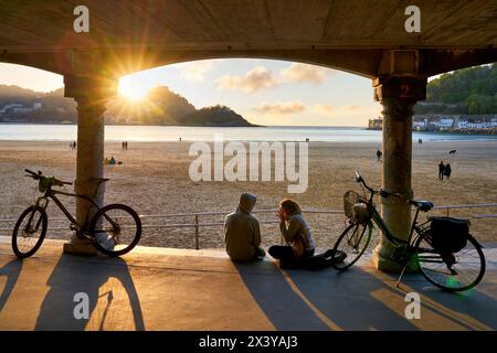 Paare mit ihren Fahrrädern, Sonnenuntergang am La Concha Beach, Donostiarra Juwel schlechthin, Wahrzeichen der Stadt, unvergleichliche Lage, es liegt in Th Stockfoto