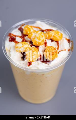 Milchshake mit Popcorn in einem Plastikbecher. Stockfoto