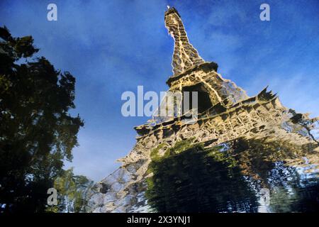 Der Eiffelturm in Paris, Frankreich, spiegelt sich in einem Wasserbecken, das von einem Regensturm zurückgelassen wurde. Stockfoto