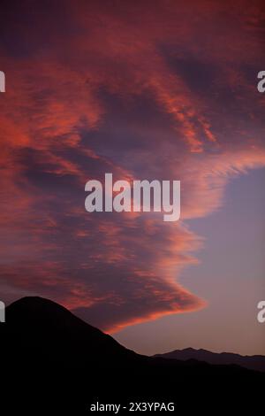 Die Dämmerung bildet Berge unter einem lebendigen, feurigen Himmel. Stockfoto