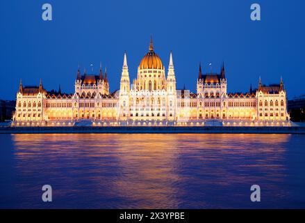 Parlament in Budapest bei Nacht, beleuchtetes historisches Gebäude, das sich im Wasser des Flusses spiegelt Stockfoto