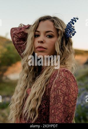 Blonde Schönheit mit Lupinenblüte, ein Porträt der Anziehungskraft Stockfoto