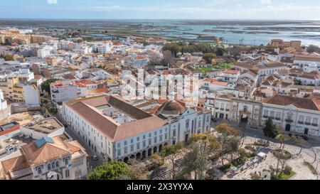 Traditionelle portugiesische Stadt Faro am Meer mit alter Architektur, gefilmt von Drohnen. Ria formosa im Hintergrund. Stockfoto