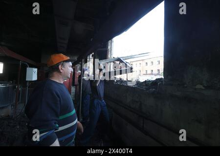 CHARKIW, UKRAINE - 27. APRIL 2024 - Männer reinigen die Räumlichkeiten des Psychiatrischen Krankenhauses N3 im Bezirk Saltivskyi nach einem nächtlichen russischen S-300 Raketenangriff in Charkiw, Nordostukraine. Am 27. April um 00:30 Uhr Ortszeit griffen russische Truppen das Psychiatrische Krankenhaus N3 in Charkiw mit S-300-Luftabwehrraketen an. Fenster, Dach, nicht genutztes Gebäude, Lebensmittelblock, Heizraum und andere Gebäude wurden beschädigt. Eine 53-jährige Frau wurde verletzt. Während des Streiks waren 60 Patienten und 5 Krankenhausmitarbeiter anwesend. Stockfoto