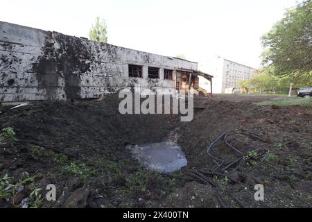 CHARKIW, UKRAINE - 27. APRIL 2024 - Ein Krater im Psychiatrischen Krankenhaus N3 im Bezirk Saltivskyi wird nach einem nächtlichen russischen Raketenangriff auf die S-300 in Charkiw, Nordostukraine gesehen. Am 27. April um 00:30 Uhr Ortszeit griffen russische Truppen das Psychiatrische Krankenhaus N3 in Charkiw mit S-300-Luftabwehrraketen an. Fenster, Dach, nicht genutztes Gebäude, Lebensmittelblock, Heizraum und andere Gebäude wurden beschädigt. Eine 53-jährige Frau wurde verletzt. Während des Streiks waren 60 Patienten und 5 Krankenhausmitarbeiter anwesend. Stockfoto