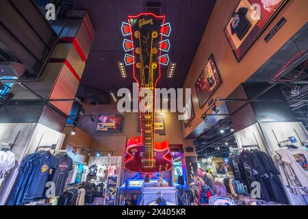 Blick auf das Innere der Hard Rock Cafe Boutique mit dekorativer, übergroßer Gitarre von der Decke, deren Saiten synchron mit Musik beleuchtet werden. NEW YORK USA. Stockfoto