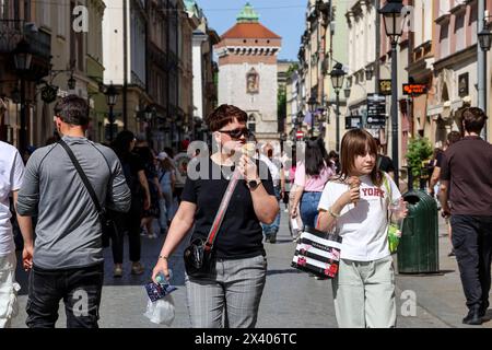 Krakau, Polen. April 2024. Menschen mit Eiskrem werden auf einem Hauptmarkt in der Altstadt von Krakau gesehen, während eine Hitzewelle in Polen eintrifft, die fast 30 Grad Celsius erreicht - eine sehr ungewöhnliche Temperatur für April. Quelle: SOPA Images Limited/Alamy Live News Stockfoto