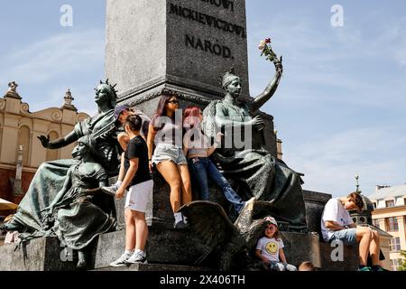 Krakau, Polen. April 2024. Eine Gruppe leicht gekleideter Menschen wird auf einem Hauptmarkt in der Altstadt von Krakau gesehen, als eine Hitzewelle in Polen eintrifft, die fast 30 Grad Celsius erreicht - eine sehr ungewöhnliche Temperatur für April. Quelle: SOPA Images Limited/Alamy Live News Stockfoto