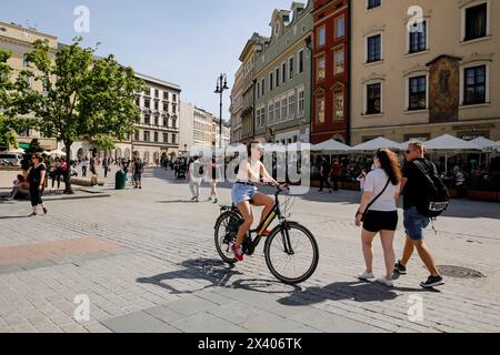 Krakau, Polen. April 2024. Leicht gekleidete Menschen werden auf dem Hauptmarkt in der Altstadt von Krakau gesehen, während eine Hitzewelle in Polen eintrifft, die fast 30 Grad Celsius erreicht - eine sehr ungewöhnliche Temperatur für April. Quelle: SOPA Images Limited/Alamy Live News Stockfoto