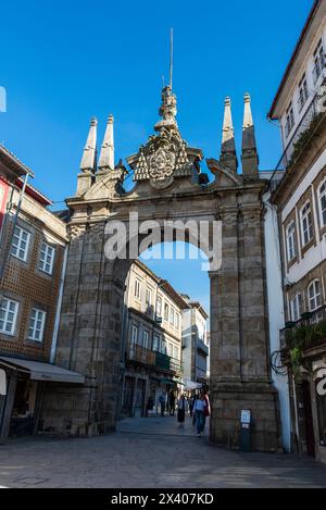 Braga, Portugal - 25. November 2023: Triumphbogen des Neuen Tores oder Arco da Porta Nova mit Menschen in der Altstadt von Braga, Portugal Stockfoto