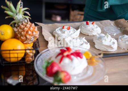 Pavlova Dessert mit frischem Obst auf Holzoberfläche, tropische Früchte sichtbar. Toll für Lebensmittelzeitschriften. Hochwertige Fotos Stockfoto