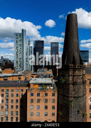 Blackened Chimney at the Rubber Works, Victorian Mills und moderne Wolkenkratzer in Manchester, England Stockfoto