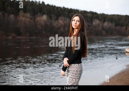 Schönes Mädchen mit langen Haaren, das an Einem sonnigen Tag in der Nähe des Flusses steht. Stockfoto