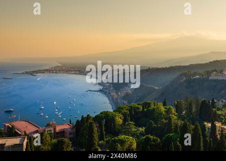 Blick auf die Stadt Taormina, Sizilien, Italien und die Küste bei Sonnenuntergang; Taormina, Sizilien, Italien Stockfoto